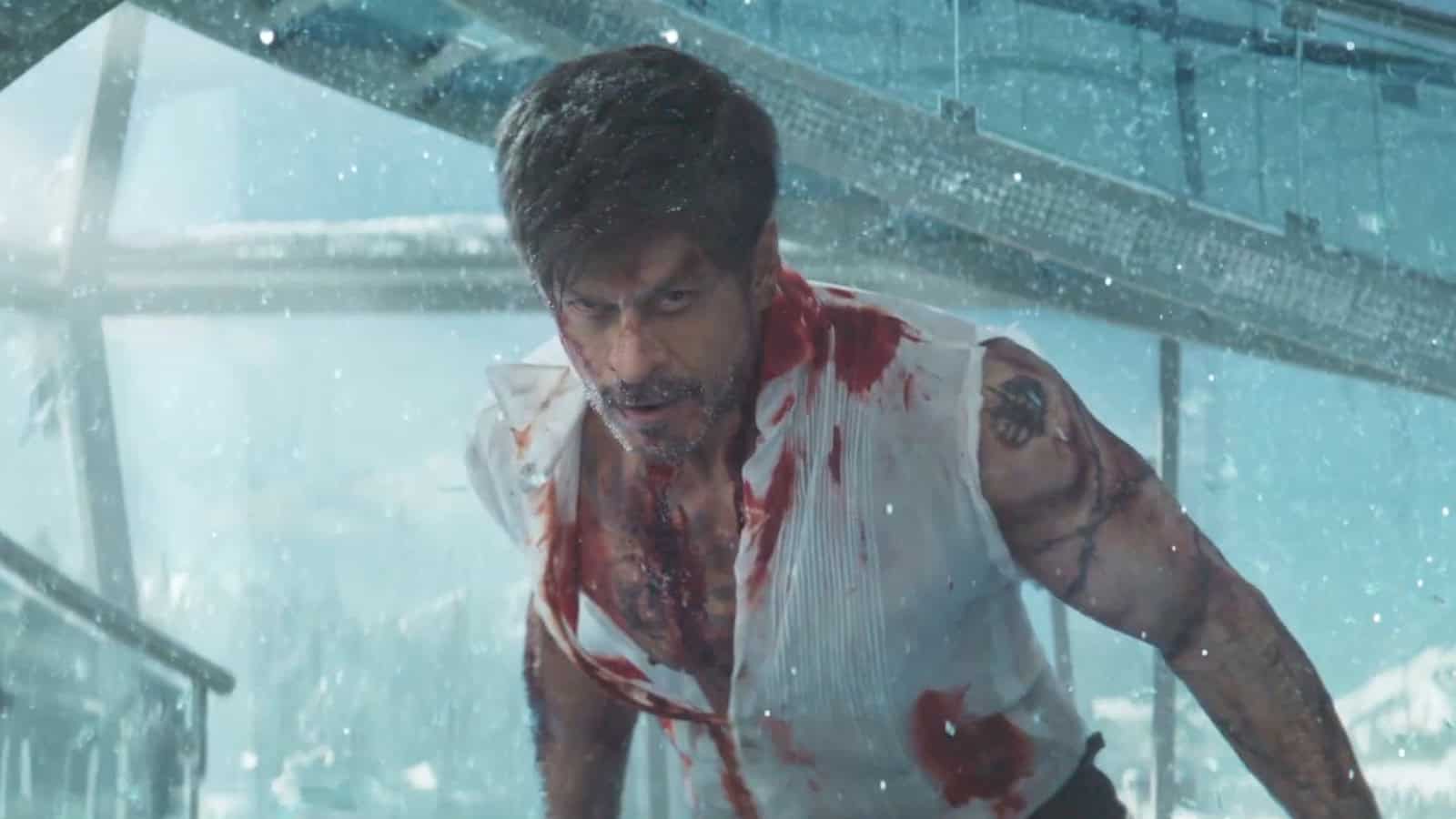 Action scene from a movie featuring a man with bloodstains on his shirt, intense expression, and a rainy.