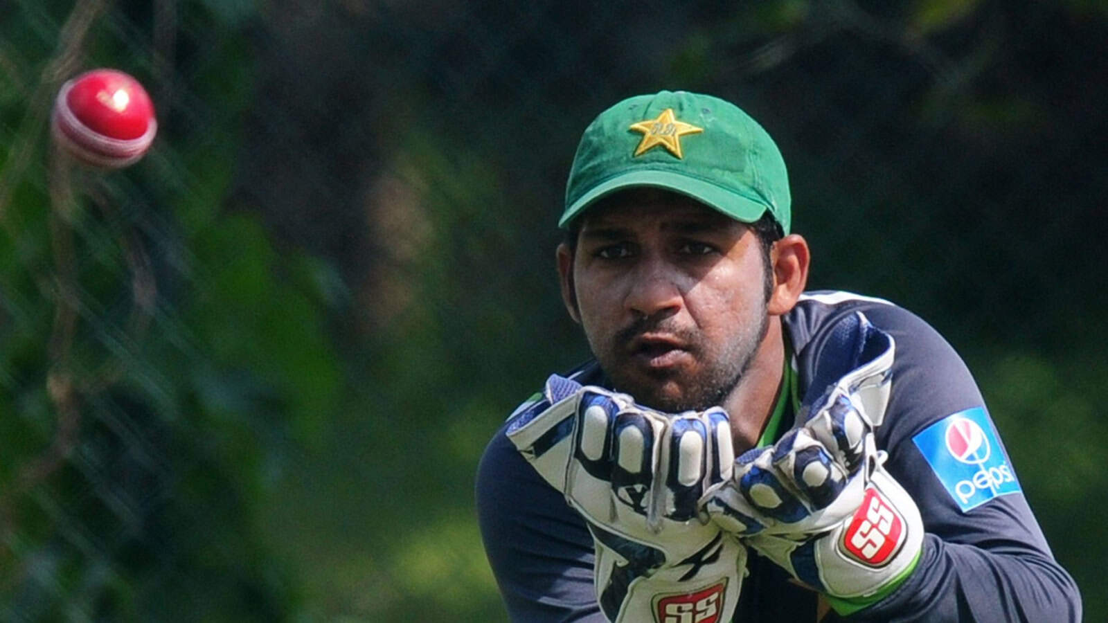 Pakistan's young cricket coach practicing fielding drills during training.