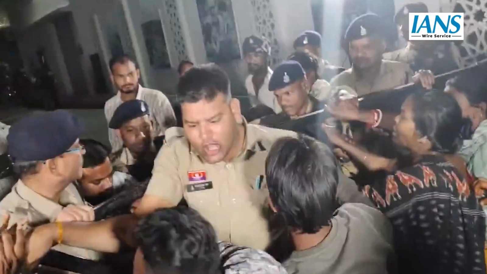 A police officer tries to control protestors outside the hospital