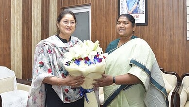 Telangana minister Seethakka with a woman holding a bouquet, advocating for higher wages for crèche worke.