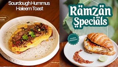 Sourdough hummus haleem toast garnished with herbs on a white plate.