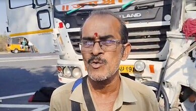 Man speaking at the scene of a road accident involving a sand tipper and RTC bus in Telangana.