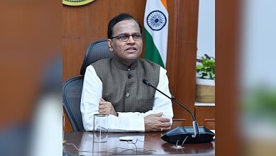 Telangana Chief Secretary seated at desk with Indian flag, discussing digital dashboard for tracking inve.