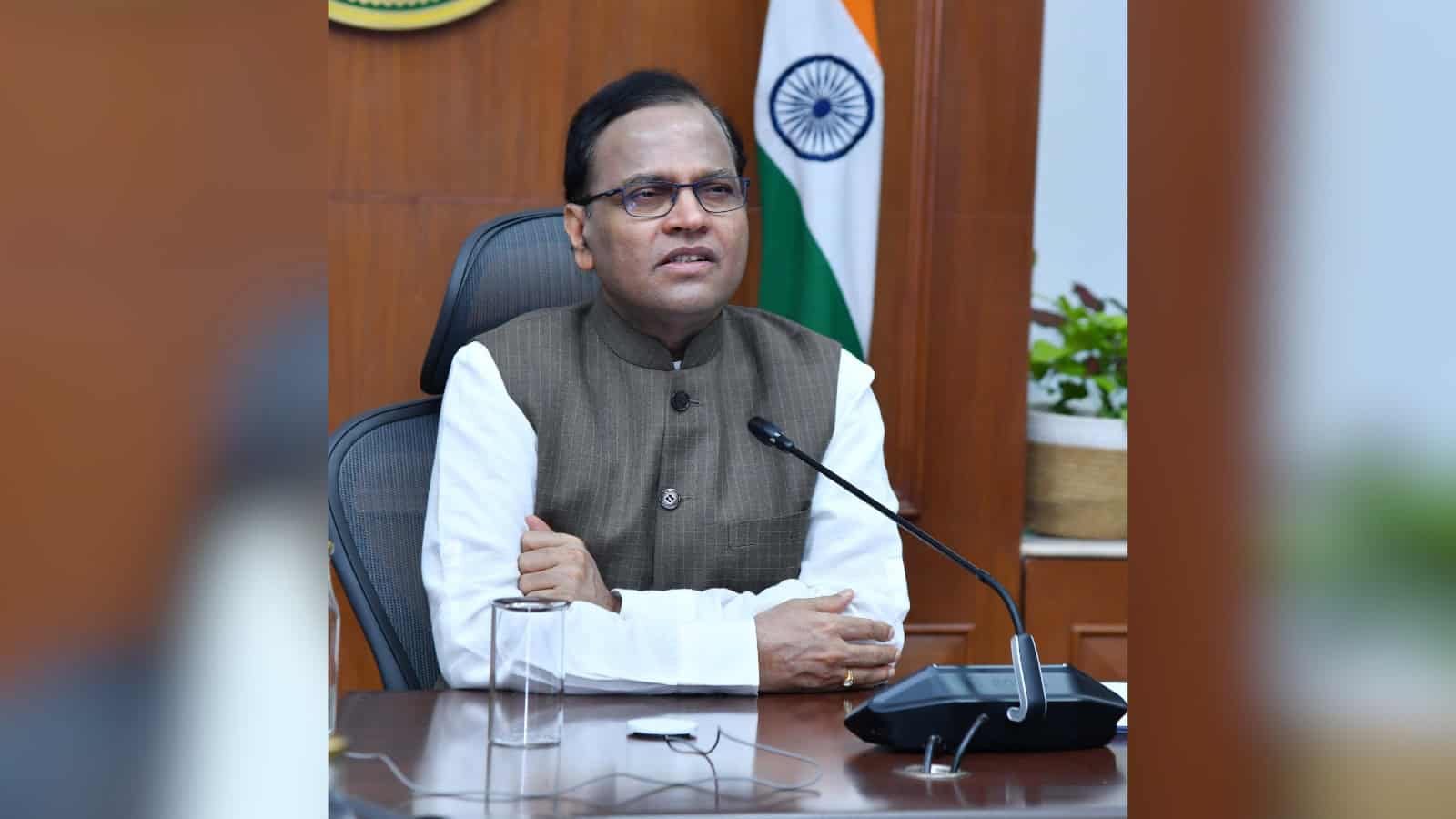 Telangana Chief Secretary seated at desk with Indian flag, discussing digital dashboard for tracking inve.