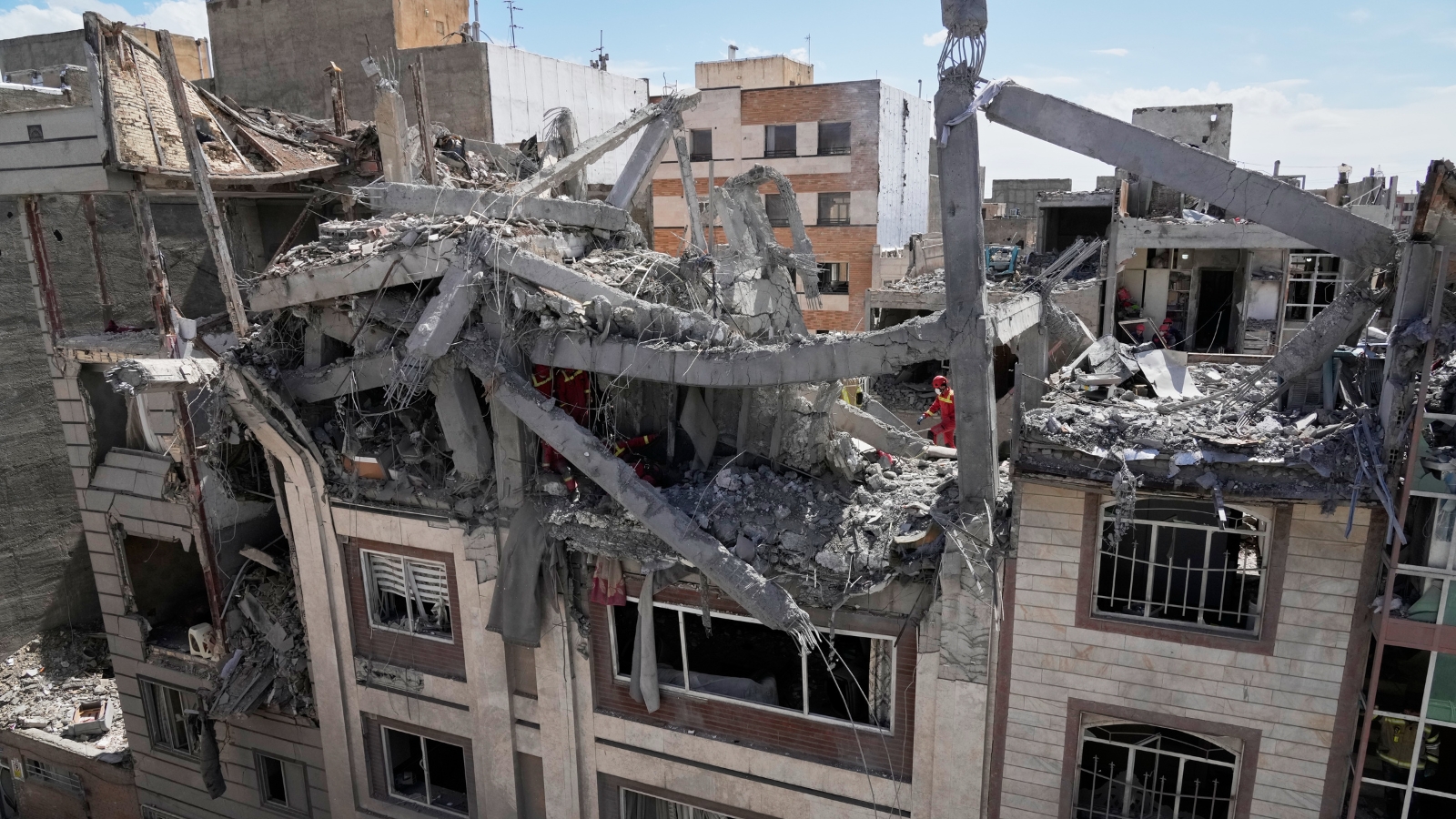 First responders inspect a residential building hit in an earlier US-Israeli strike in Tehran on Friday, March 27.