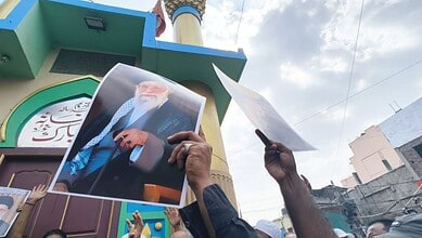 Shia protesters hold banners and photos during rally in Old City against Iran's Khamenei.