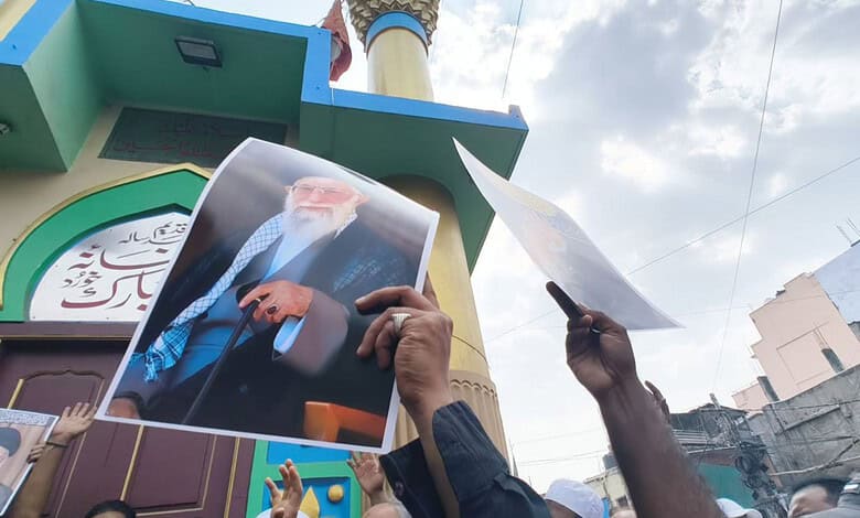 Shia protesters hold banners and photos during rally in Old City against Iran's Khamenei.