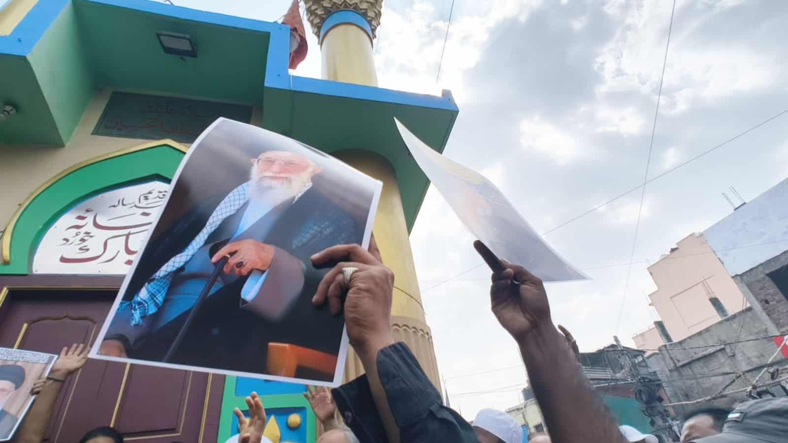 Shia protesters hold banners and photos during rally in Old City against Iran's Khamenei.