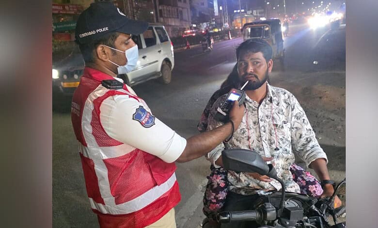 Police officer checks a motorcyclist for drunk driving during night patrol in Cyberabad.
