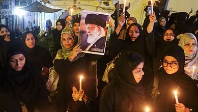 Crowd of women protesting with candles and photos, heightened security in Delhi following recent unrest.