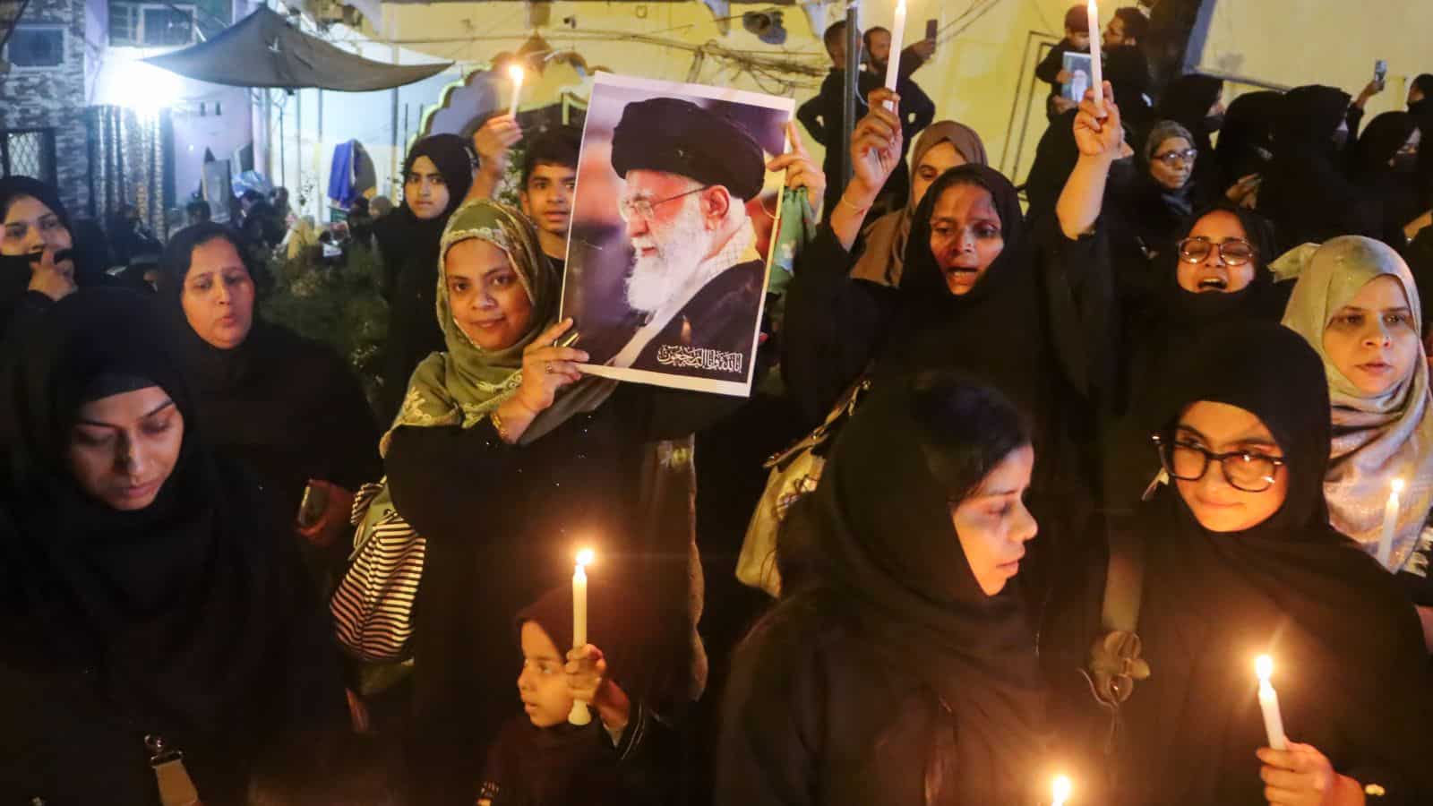Crowd of women protesting with candles and photos, heightened security in Delhi following recent unrest.