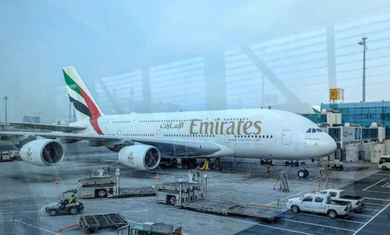 Emirates Boeing 777 aircraft parked at Dubai International Airport terminal.