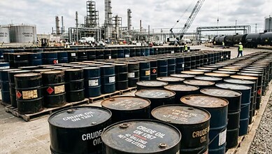 Oil barrels stacked at a refinery or storage facility.