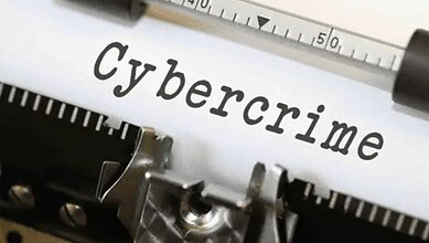 Close-up of the word "cybercrime" on a typewriter with a pen, highlighting cyber fraud issues.
