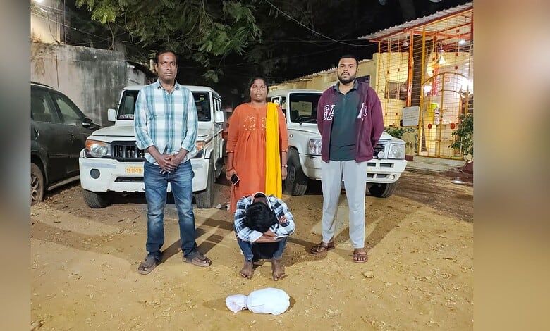 Arrested individual with police officers and seized ganja in Dhoolpet, Hyderabad, during a drug bust oper.