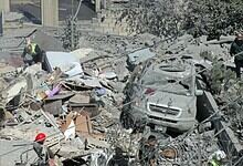 An image showing the aftermath of a military attack with damaged vehicles, rescue workers, and debris, hi.