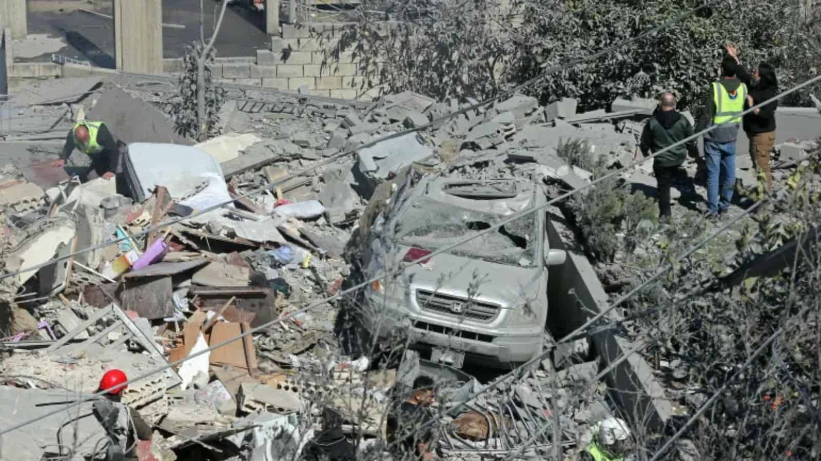 An image showing the aftermath of a military attack with damaged vehicles, rescue workers, and debris, hi.