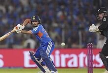 Cricket player batting with a bat while the wicketkeeper prepares behind the stumps during a match.