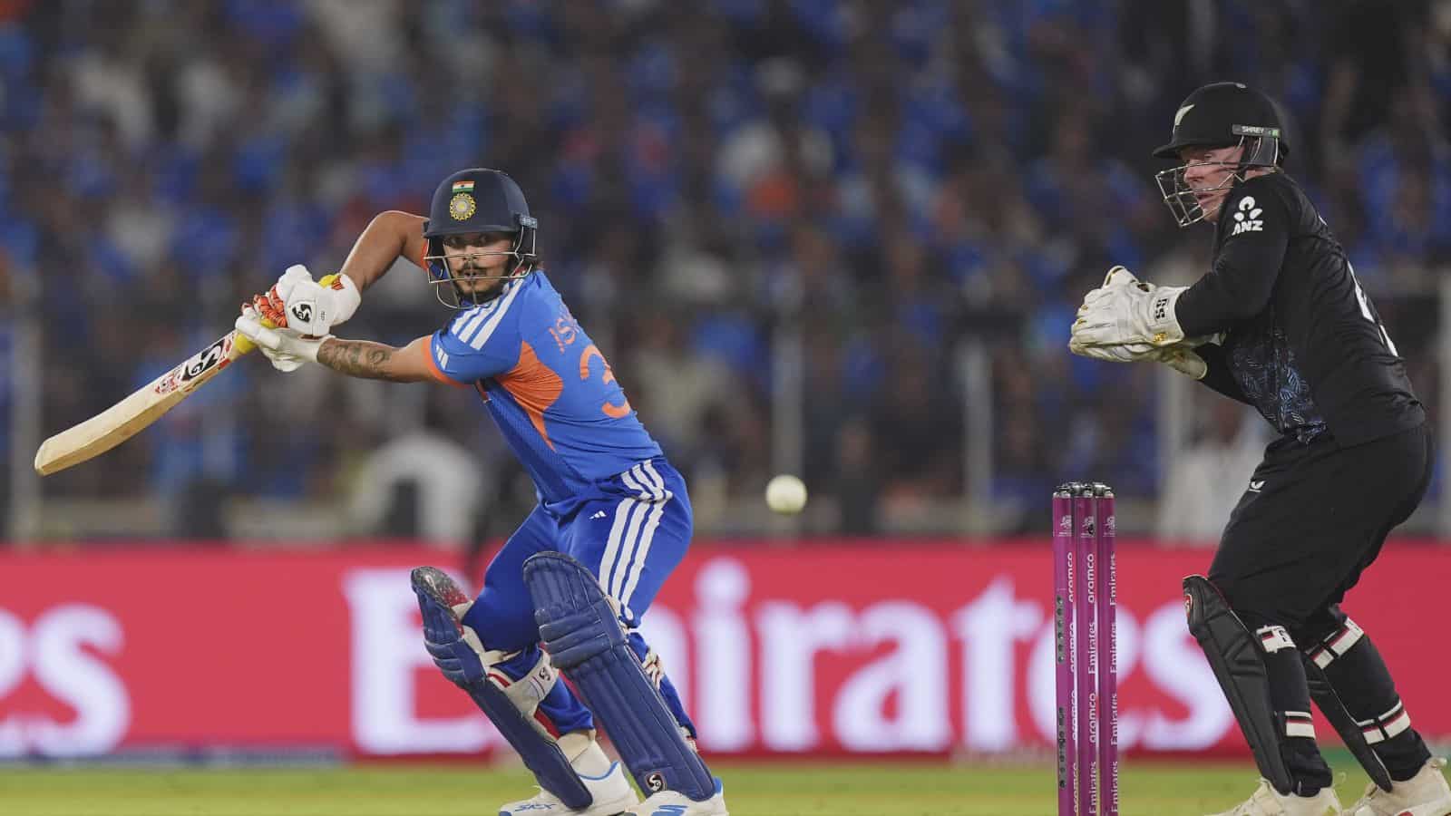 Cricket player batting with a bat while the wicketkeeper prepares behind the stumps during a match.