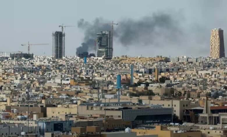 Explosion and smoke over a city skyline with ongoing construction and urban development.