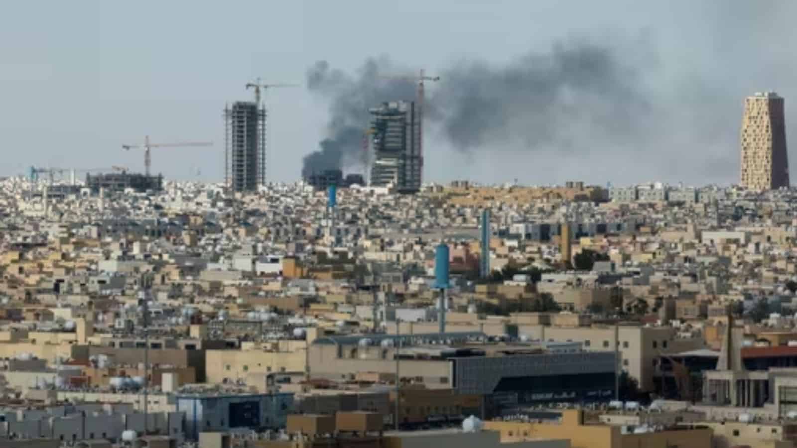 Explosion and smoke over a city skyline with ongoing construction and urban development.