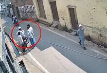 Hate crime in UP: group of people gathered on the street, with one individual walking away, underlining s.