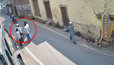 Hate crime in UP: group of people gathered on the street, with one individual walking away, underlining s.