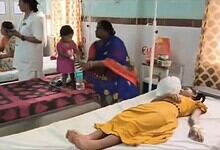 Hospital scene with children and a woman attending to a patient in a yellow dress.