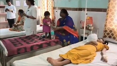 Hospital scene with children and a woman attending to a patient in a yellow dress.