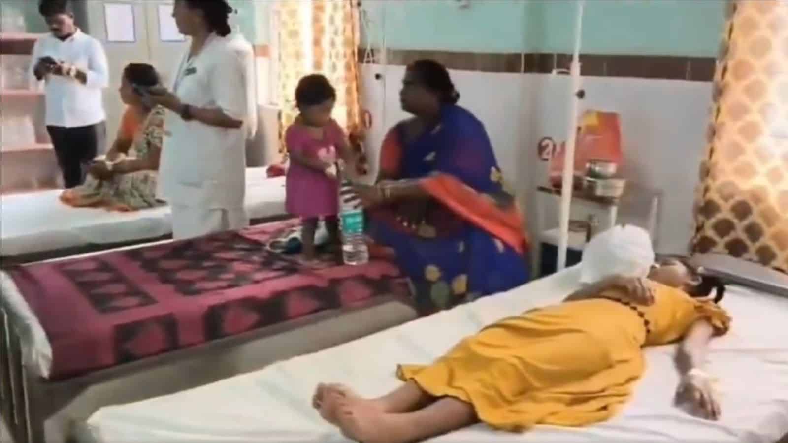 Hospital scene with children and a woman attending to a patient in a yellow dress.