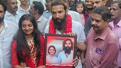 A man holding a framed photo of Monalisa Bhosle, surrounded by friends and family during her wedding at T.