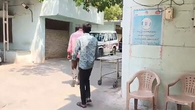 Man being detained outside a building in Hyderabad related to health and safety concerns.