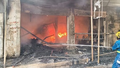Fire engulfing a building near Farooq Nagar bus stand in Falaknuma, with firefighters responding to the b.