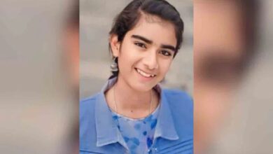 Young pregnant woman smiling, wearing blue, in a news-related image.