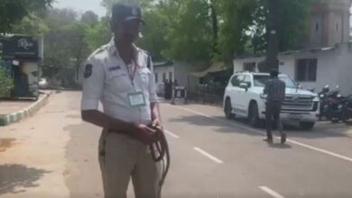 Traffic constable holds the snake found on Telangana Assembly