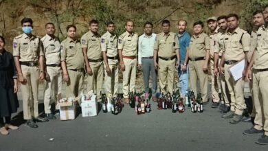 Telangana excise officials with seized liquor bottles