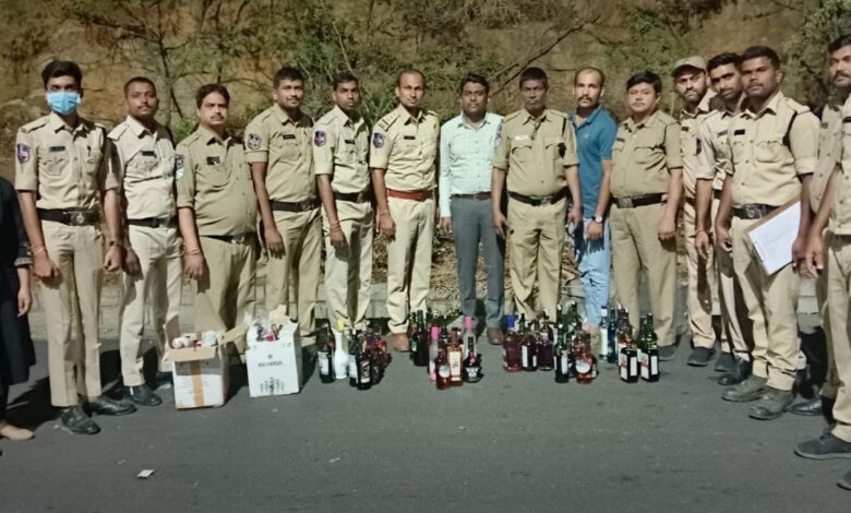 Telangana excise officials with seized liquor bottles