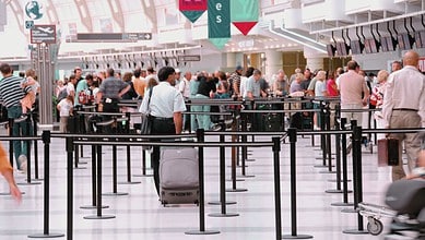 Indian travellers waiting in long queues at airport due to US-Israel strikes on Iran.