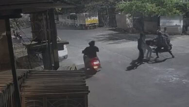 Young men on scooters and pedestrians creating disorder on the street in Warangal’s Mills Colony.