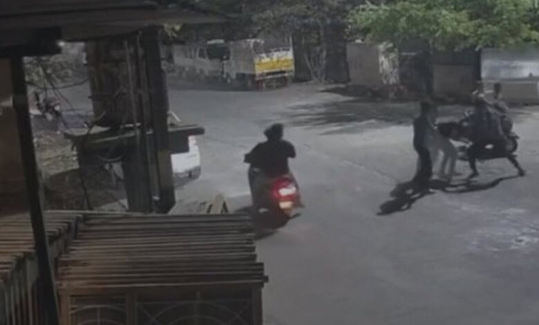 Young men on scooters and pedestrians creating disorder on the street in Warangal’s Mills Colony.