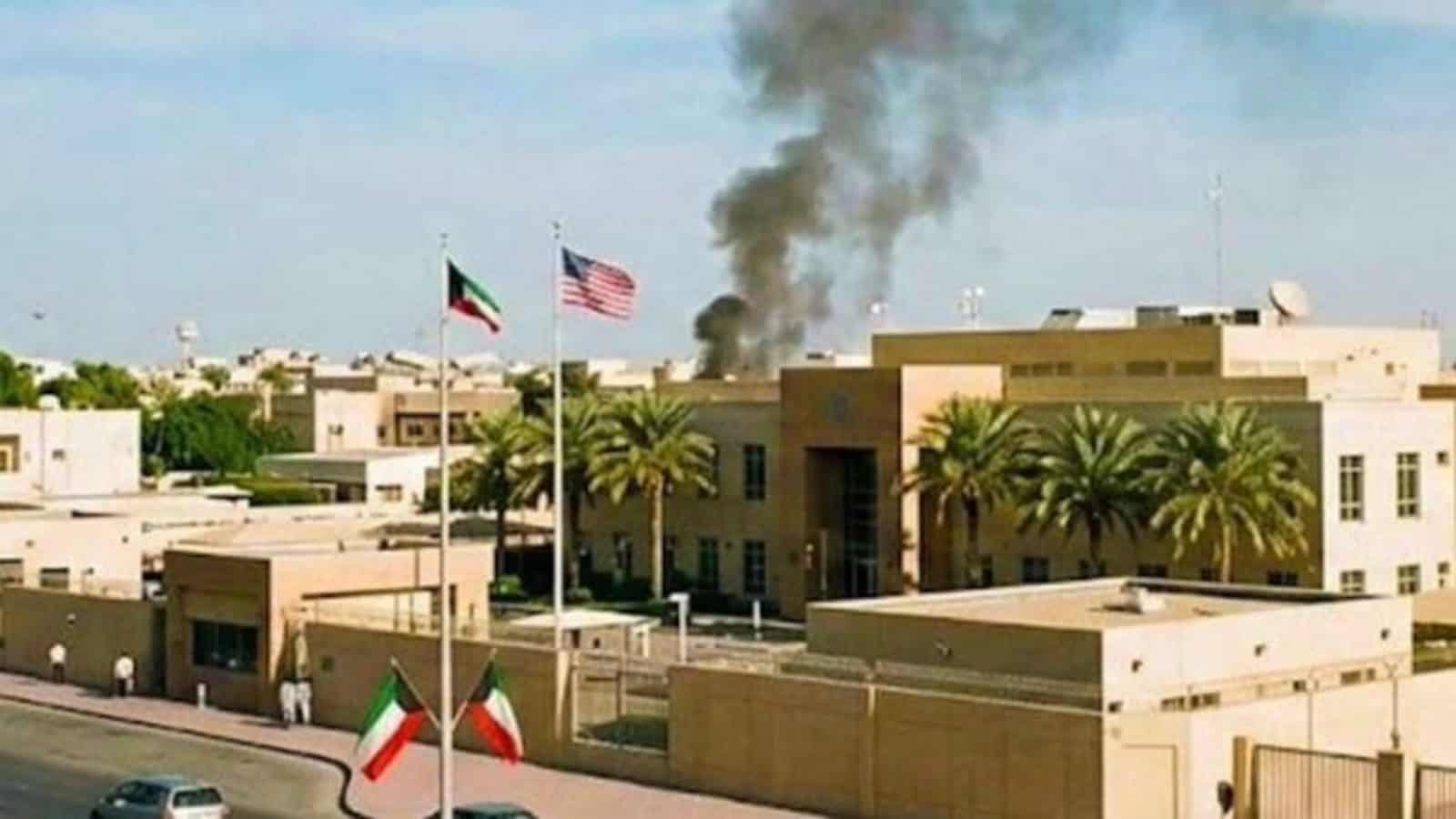 Black smoke rises near the US embassy compound in Kuwait as American and Kuwaiti flags fly outside the building.