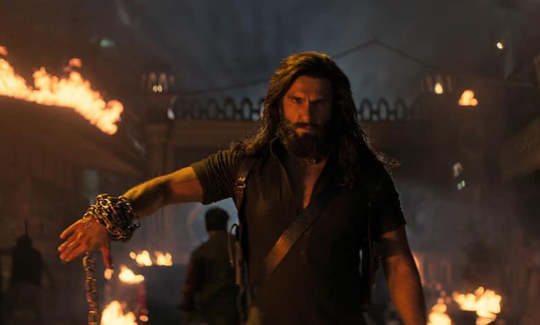 A dramatic scene from the Dhurandhar 2 trailer featuring a intense male character amidst fire and chaos.