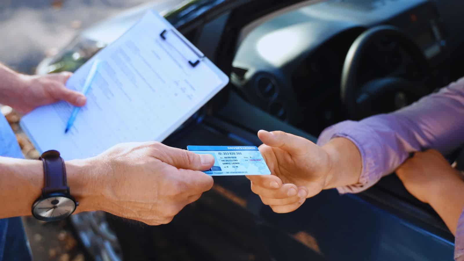 Police officer issuing a fine to a driver without a license during a traffic stop.