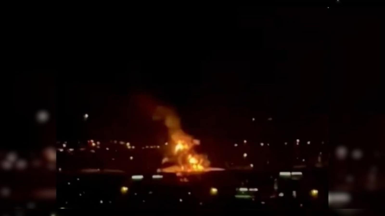 Fire at Dubai airport caused by drone strike, massive flames and smoke visible at night.