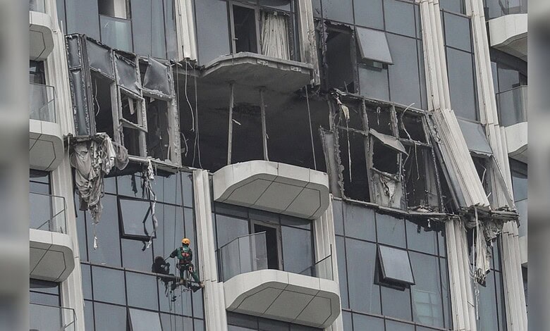 Damaged Dubai building with broken windows and debris after drone debris hit during regional conflict.