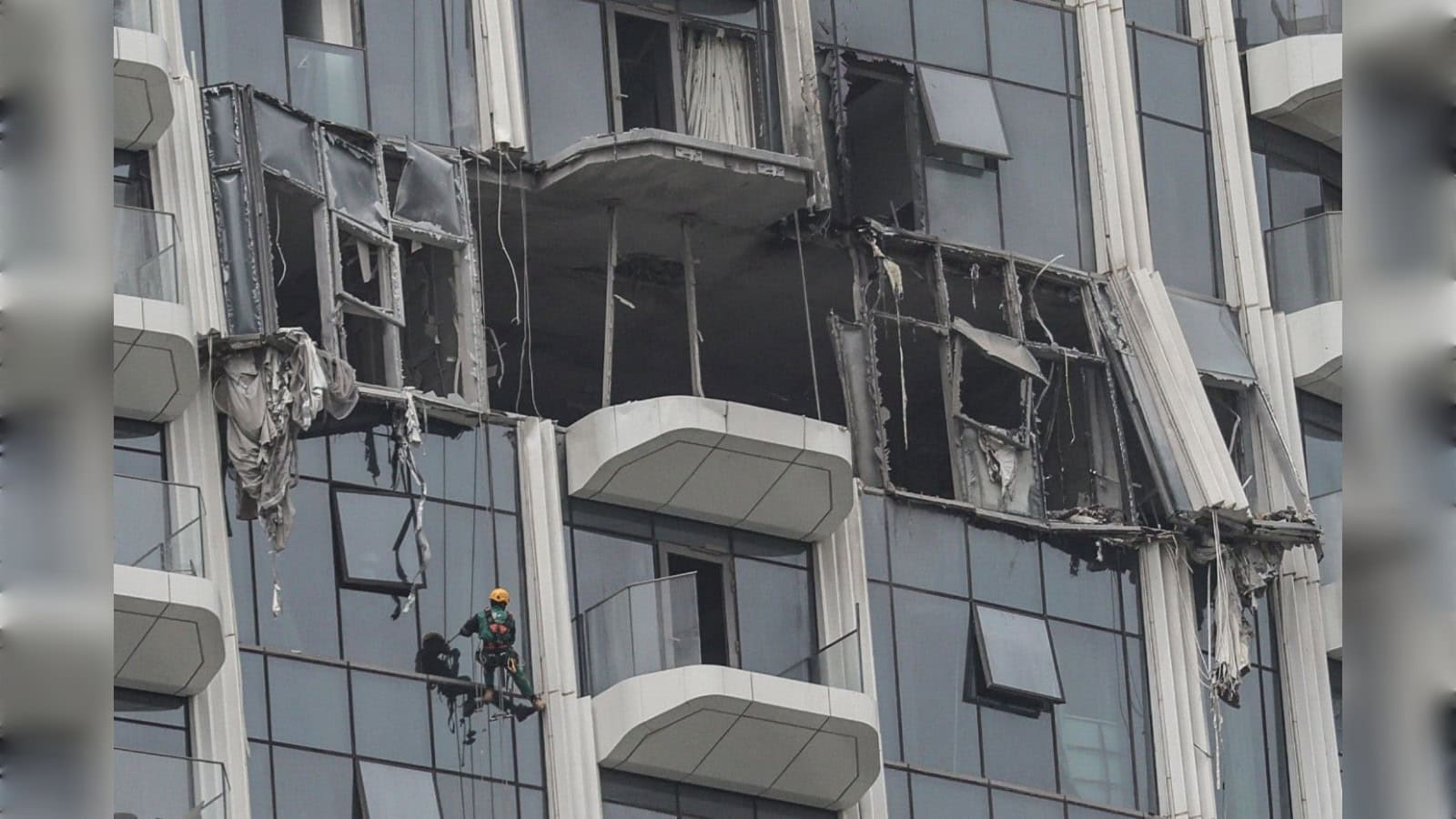 Damaged Dubai building with broken windows and debris after drone debris hit during regional conflict.
