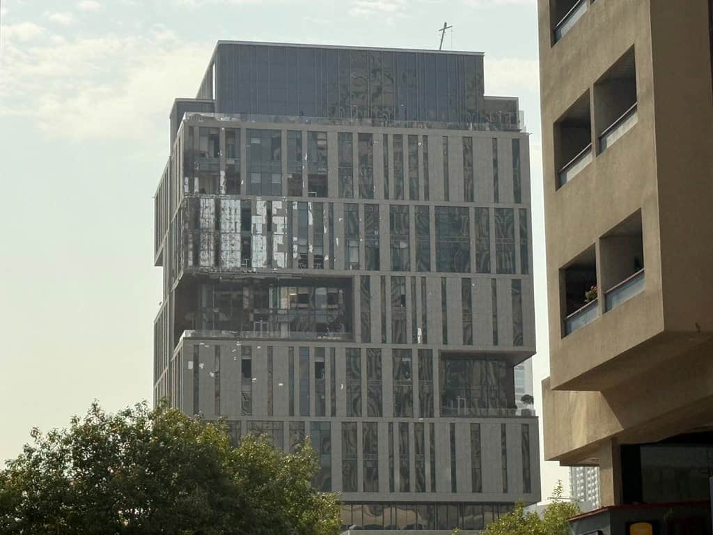 Facade of a high-rise building in Dubai’s International Financial Centre showing visible damage following a reported drone incident.