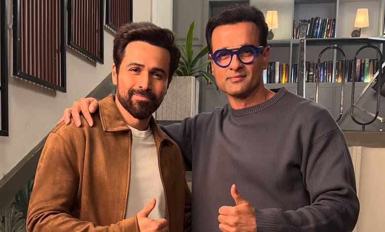 Rohit Roy and Emraan Hashmi posing together, smiling, in a modern indoor setting.
