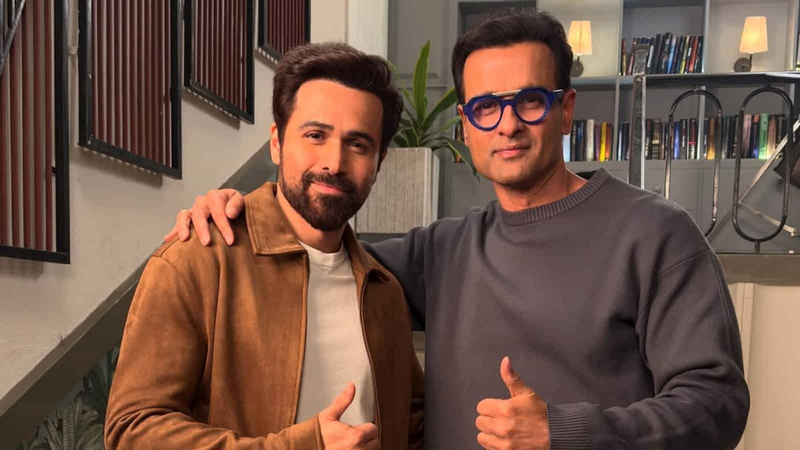 Rohit Roy and Emraan Hashmi posing together, smiling, in a modern indoor setting.