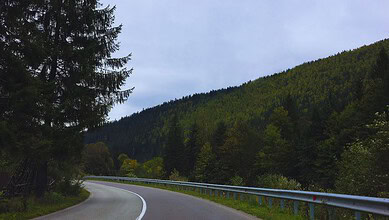 Scenic mountain highway with lush green trees and a winding road, set to be completed by December, linkin.